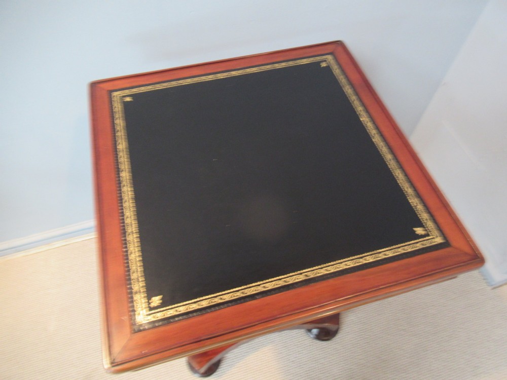 A 19th-century square mahogany side table featuring a dark leather top with gilt tooling, supported by a central turned pedestal and a quadform base. View V
