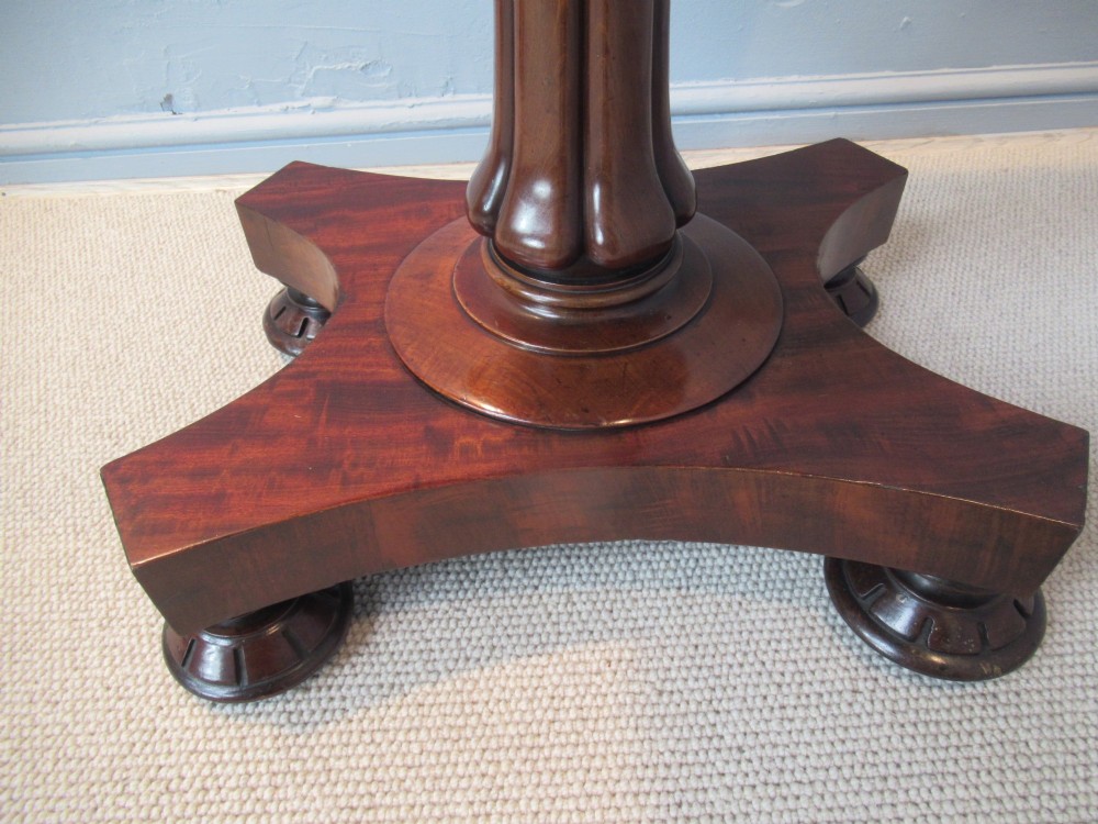 A 19th-century square mahogany side table featuring a dark leather top with gilt tooling, supported by a central turned pedestal and a quadform base. View VI