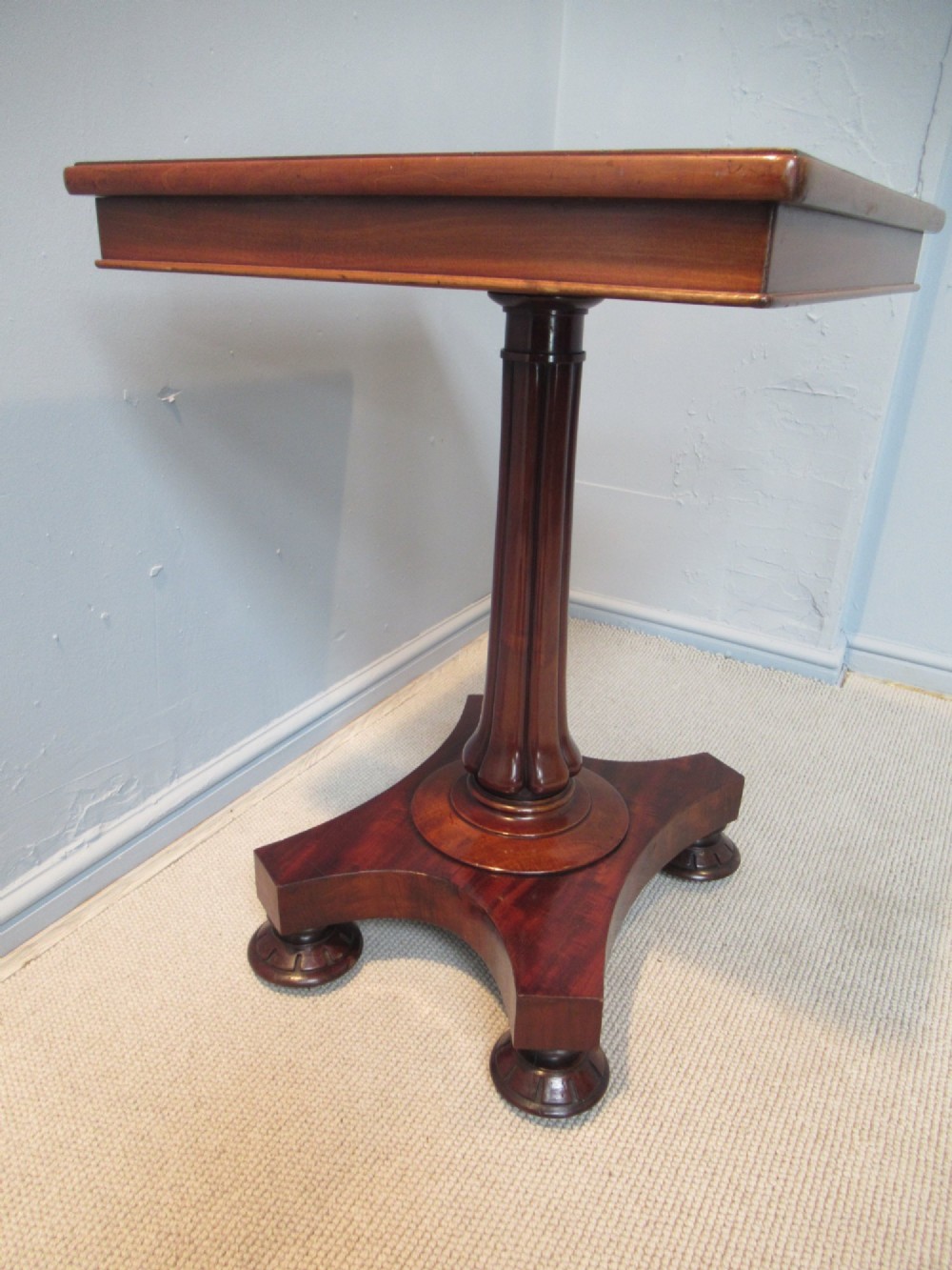 A 19th-century square mahogany side table featuring a dark leather top with gilt tooling, supported by a central turned pedestal and a quadform base. View IX