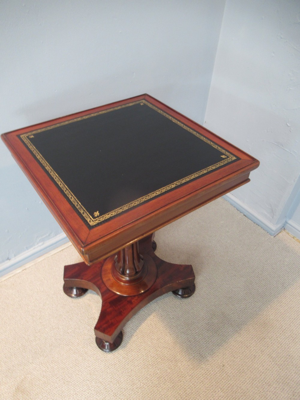 A 19th-century square mahogany side table featuring a dark leather top with gilt tooling, supported by a central turned pedestal and a quadform base. View XI