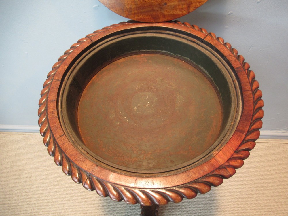 A 19th-century mahogany circular plant stand featuring a carved rope-twist rim, turned central column, and tripod base. View VIII
