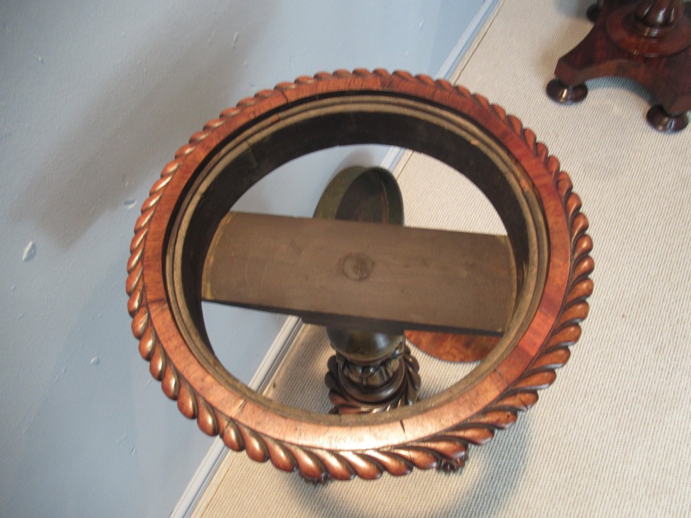 A 19th-century mahogany circular plant stand featuring a carved rope-twist rim, turned central column, and tripod base. View IX
