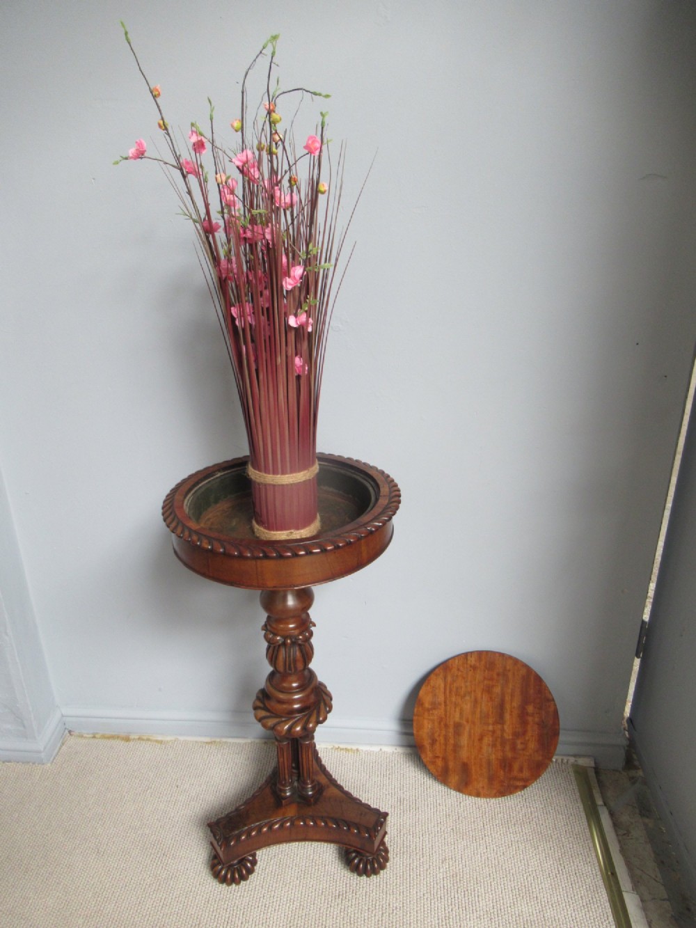 A 19th-century mahogany circular plant stand featuring a carved rope-twist rim, turned central column, and tripod base. View XII