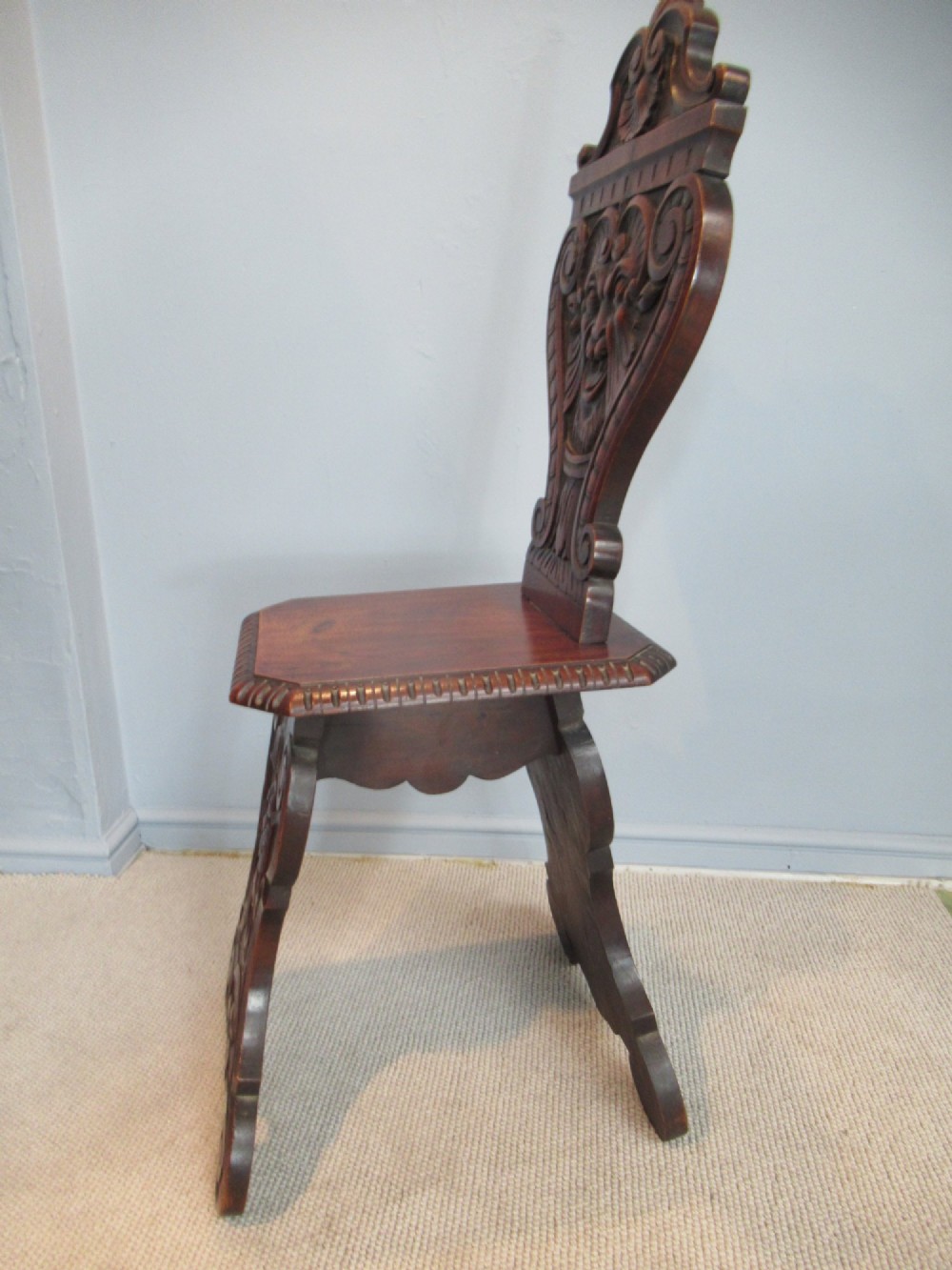 A Victorian carved mahogany hall chair featuring a detailed lion head mask sculpted into the backrest and a solid timber seat. View VI