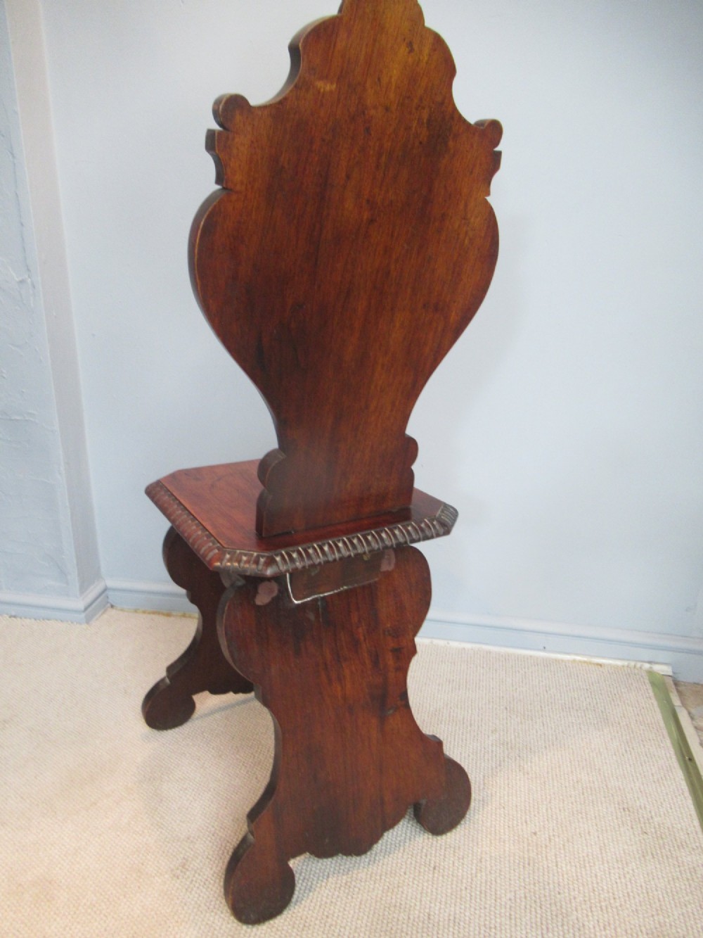 A Victorian carved mahogany hall chair featuring a detailed lion head mask sculpted into the backrest and a solid timber seat. View VII