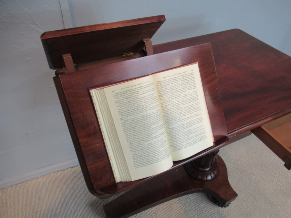 A 19th-century mahogany adjustable reading table featuring dual hinged ratcheted slopes on a turned pedestal base with an open side drawer. View IV