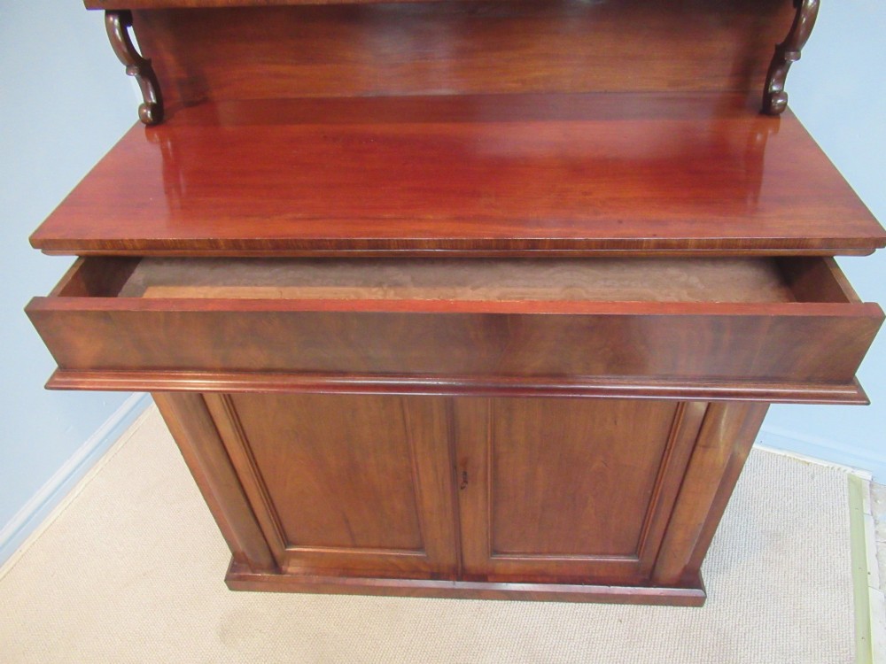A Victorian mahogany chiffonier with a raised gallery shelf supported by carved scrolls above a two-door cabinet on a solid plinth base. View VIII