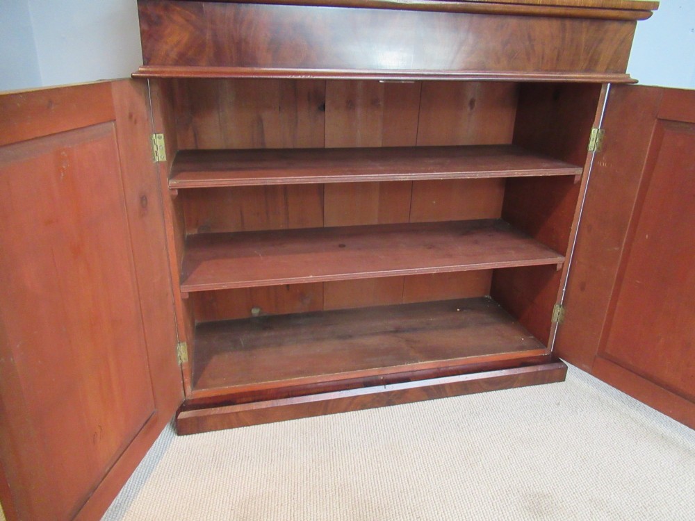 A Victorian mahogany chiffonier with a raised gallery shelf supported by carved scrolls above a two-door cabinet on a solid plinth base. View X