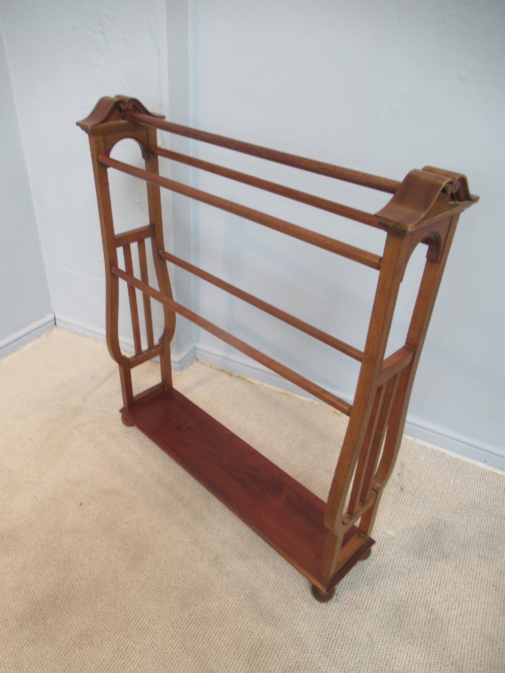 A freestanding Victorian walnut towel rail featuring carved end supports, curved pediment top caps, multiple horizontal wooden rungs, and a flat lower shelf. View II