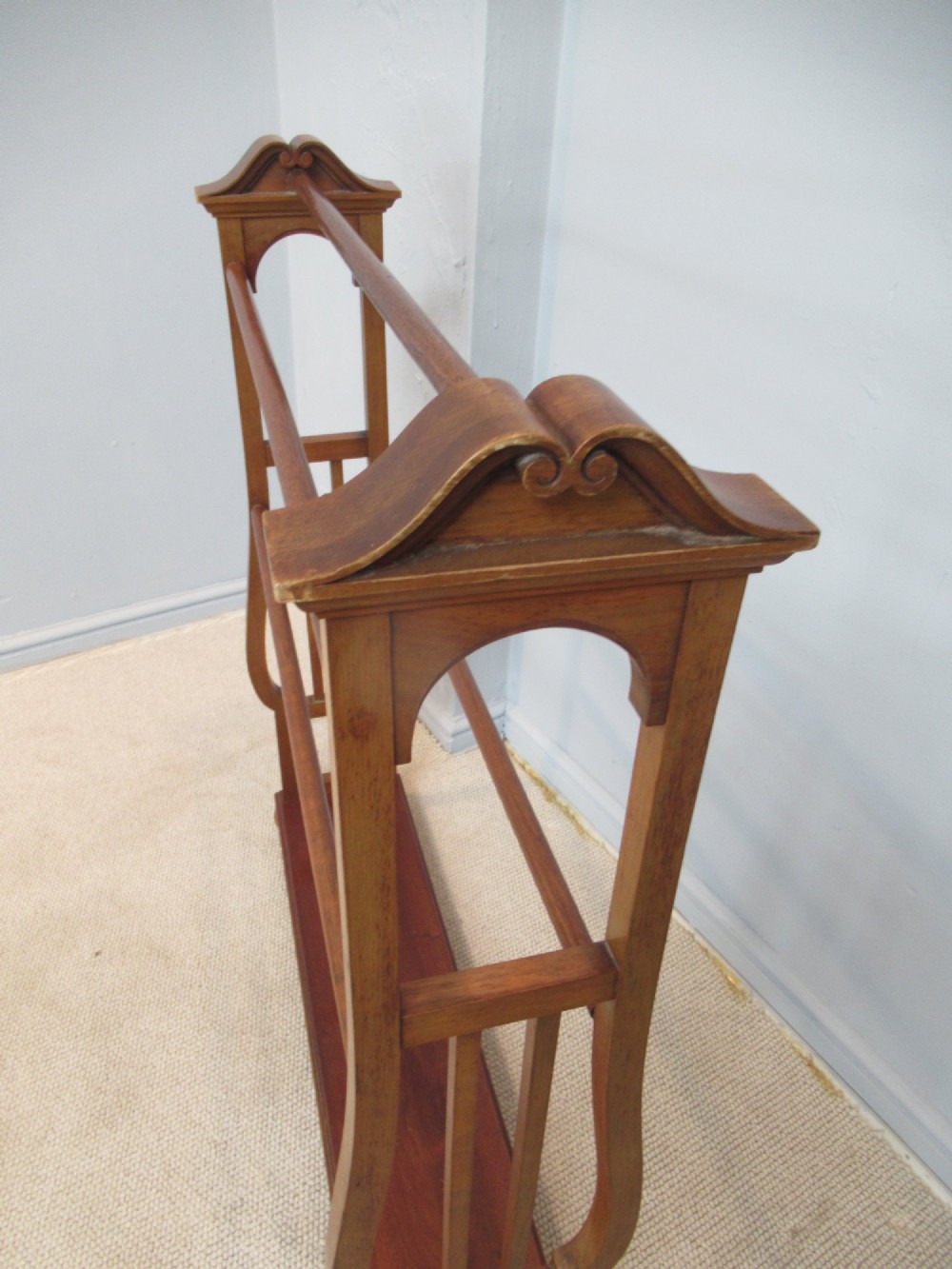 A freestanding Victorian walnut towel rail featuring carved end supports, curved pediment top caps, multiple horizontal wooden rungs, and a flat lower shelf. View III