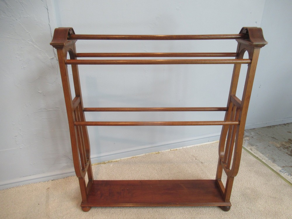 A freestanding Victorian walnut towel rail featuring carved end supports, curved pediment top caps, multiple horizontal wooden rungs, and a flat lower shelf. View IV