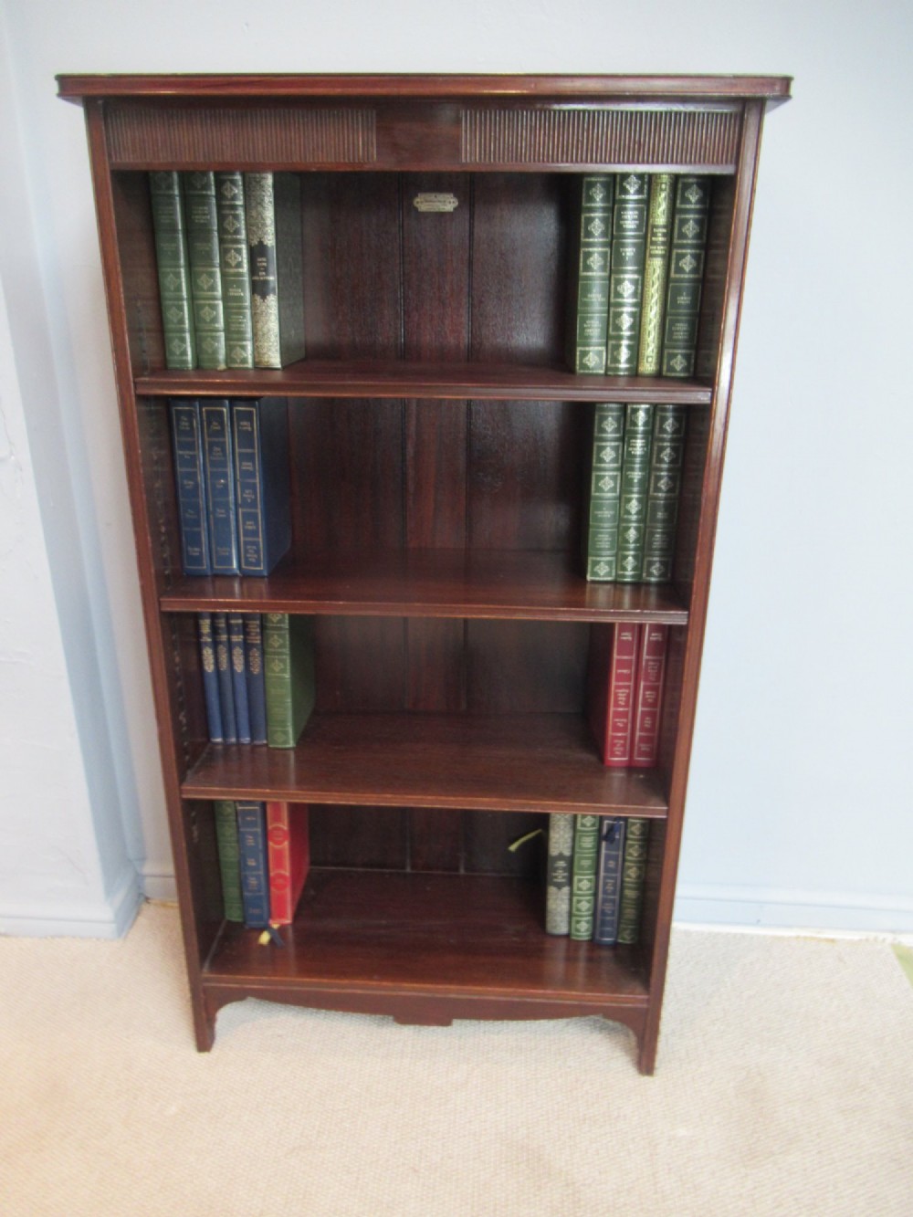 An antique dark mahogany open bookcase featuring four adjustable shelves, fluted frieze detailing at the top, and bracket feet. View II