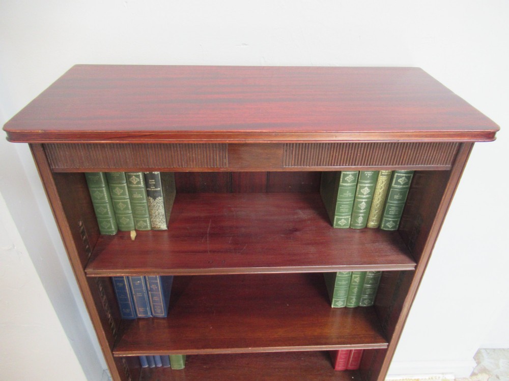 An antique dark mahogany open bookcase featuring four adjustable shelves, fluted frieze detailing at the top, and bracket feet. View IV