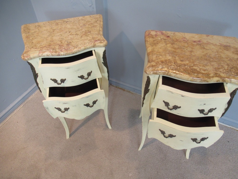A pair of cream painted French style bedside cabinets featuring variegated marble tops, two drawers with brass handles, and slender cabriole legs. View VII