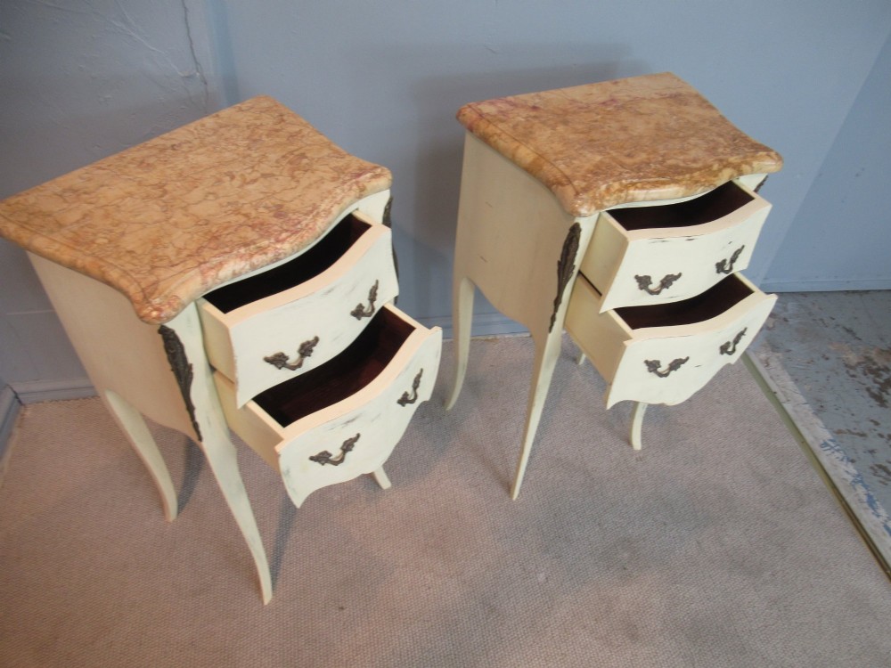 A pair of cream painted French style bedside cabinets featuring variegated marble tops, two drawers with brass handles, and slender cabriole legs. View VIII
