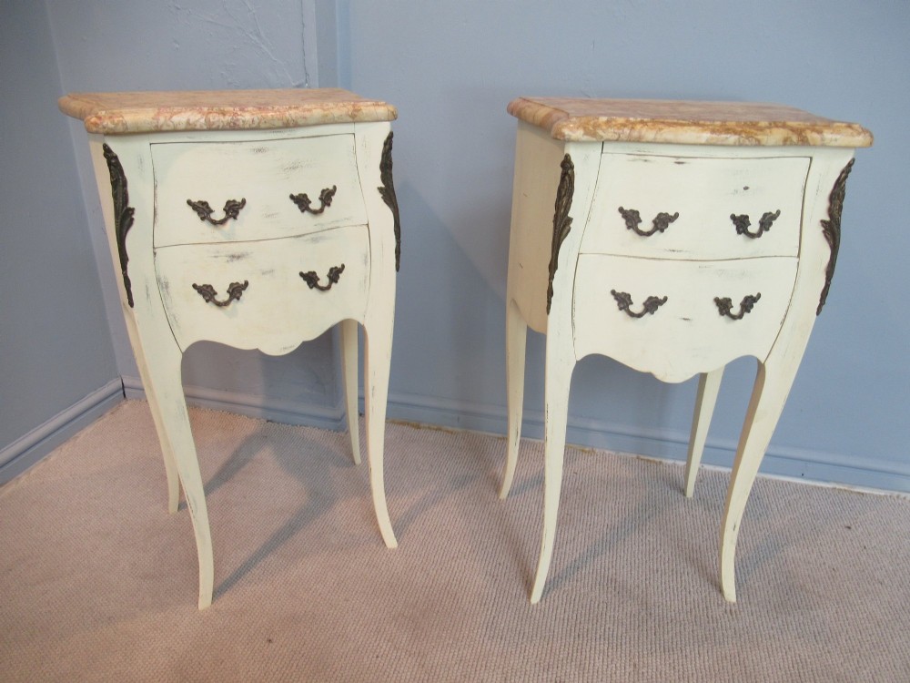A pair of cream painted French style bedside cabinets featuring variegated marble tops, two drawers with brass handles, and slender cabriole legs. View IX