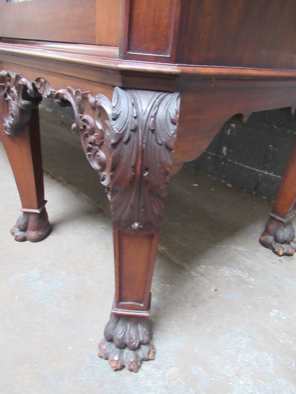 An Edwardian carved mahogany sideboard featuring a raised backboard with a carved shell motif, central bow-front drawers, side cupboard doors, and cabriole legs with ball and claw feet. View VI