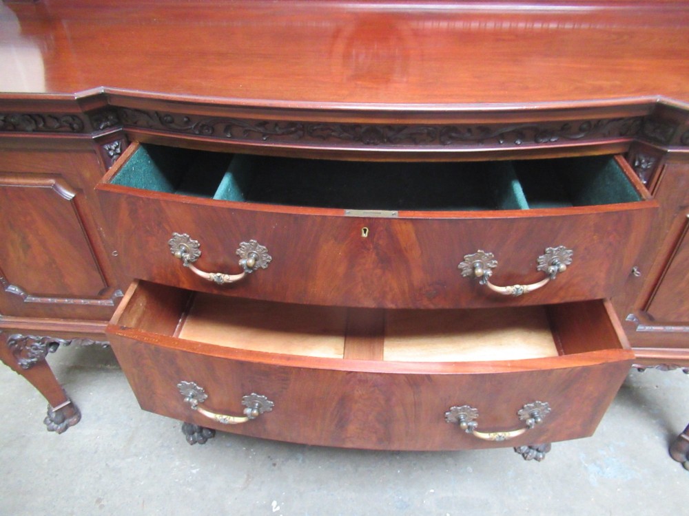 An Edwardian carved mahogany sideboard featuring a raised backboard with a carved shell motif, central bow-front drawers, side cupboard doors, and cabriole legs with ball and claw feet. View VIII