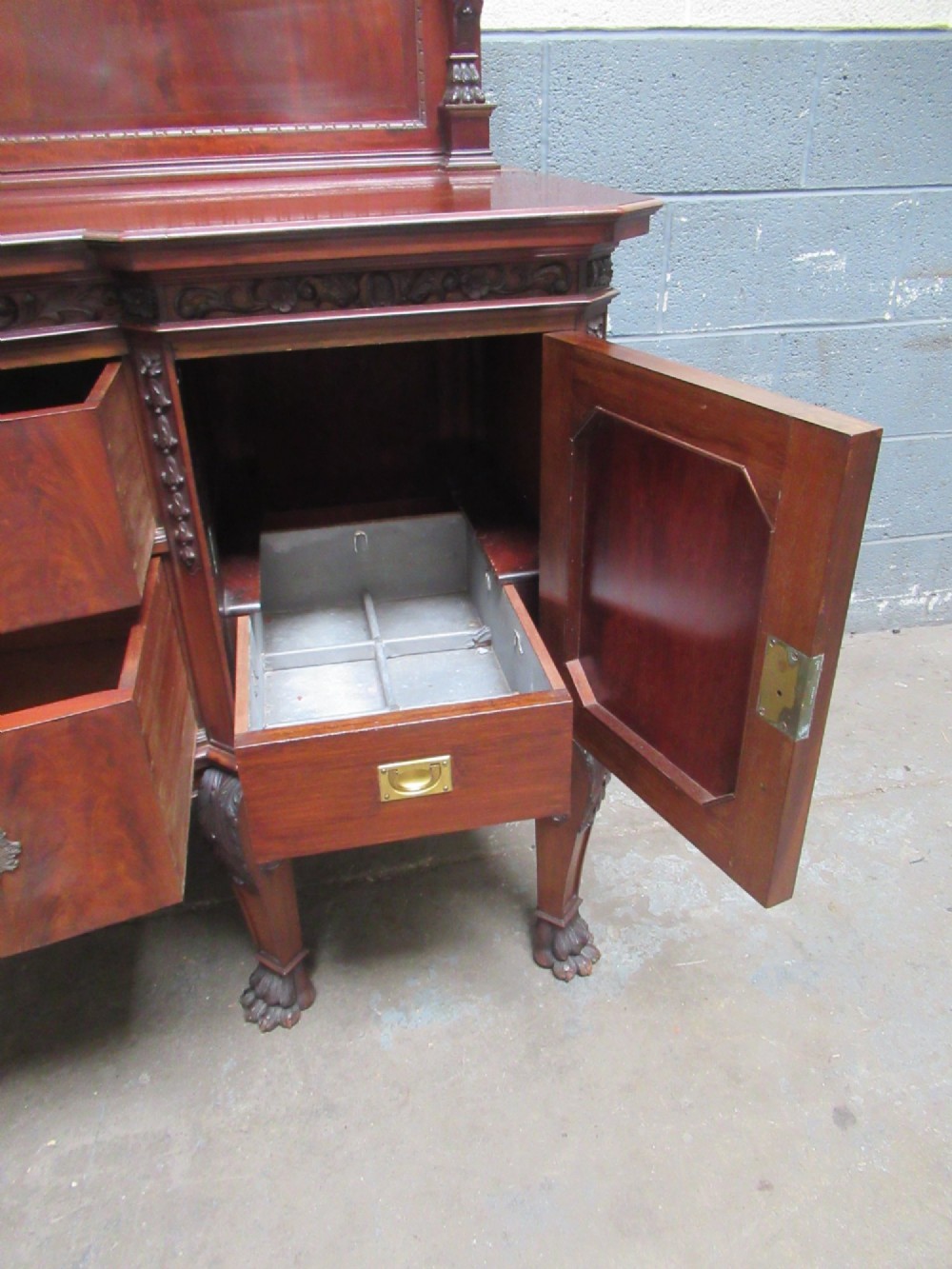 An Edwardian carved mahogany sideboard featuring a raised backboard with a carved shell motif, central bow-front drawers, side cupboard doors, and cabriole legs with ball and claw feet. View IX