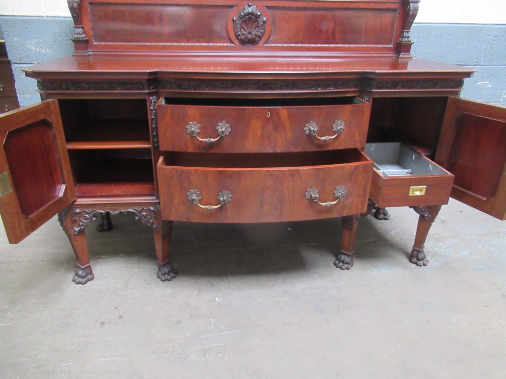 An Edwardian carved mahogany sideboard featuring a raised backboard with a carved shell motif, central bow-front drawers, side cupboard doors, and cabriole legs with ball and claw feet. View XI