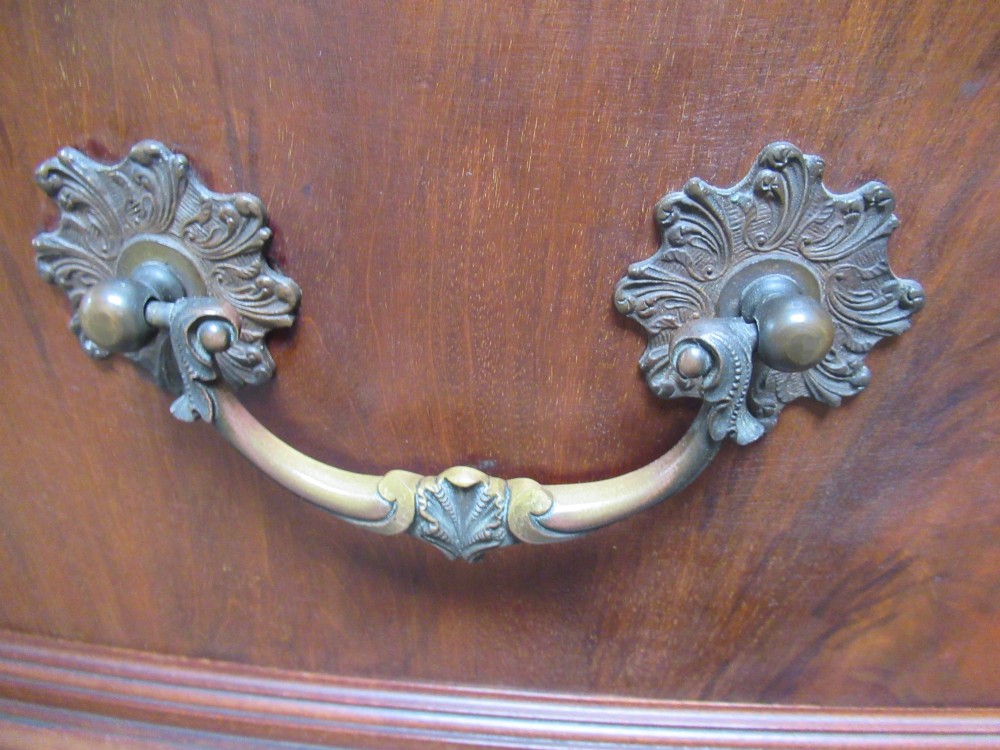 An Edwardian carved mahogany sideboard featuring a raised backboard with a carved shell motif, central bow-front drawers, side cupboard doors, and cabriole legs with ball and claw feet. View XIV
