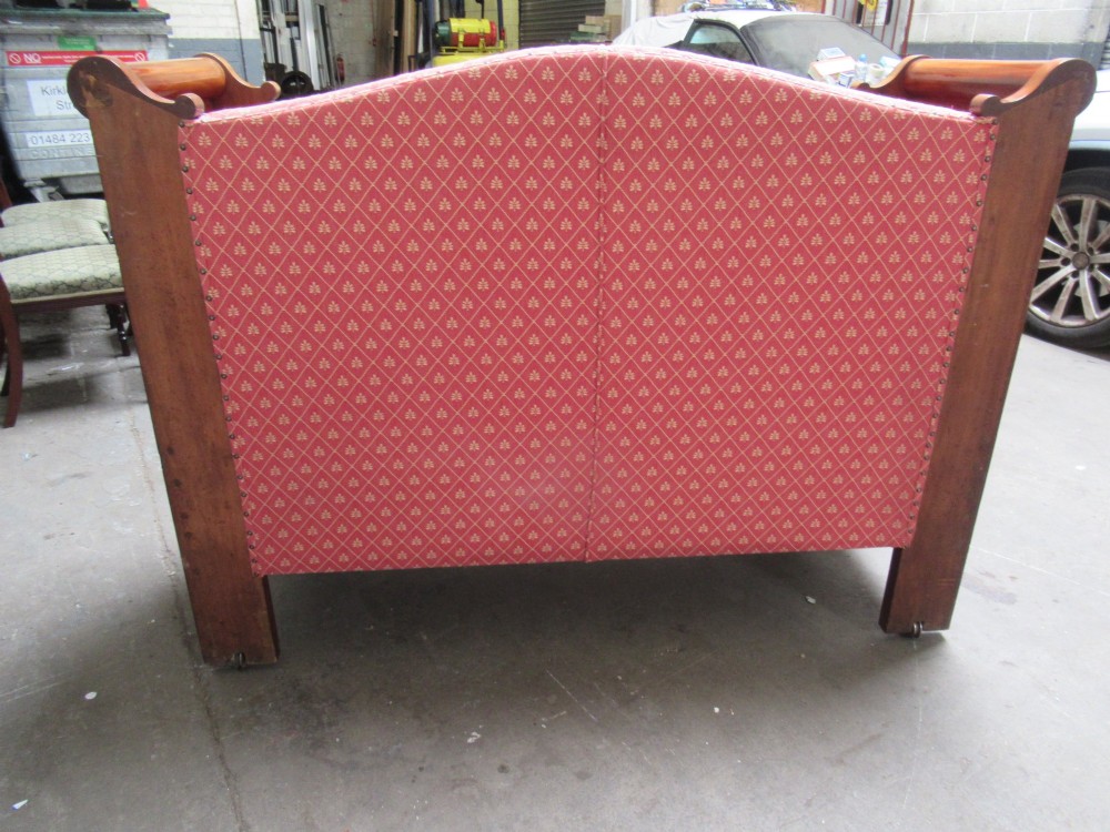 A 19th-century mahogany upholstered bench featuring scrolled armrests, flame mahogany veneered panelling, and red patterned fabric seating with bolster cushions. View IX