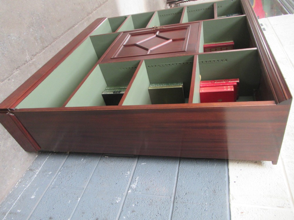 An Edwardian mahogany open bookcase with asymmetrical sage green painted shelves and a central panelled cupboard door featuring diamond moulding. View IV