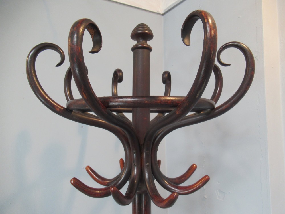 A dark brown bentwood hat and coat stand featuring multiple curved upper hooks, a central turned pole, a lower umbrella ring, and splayed legs. View V