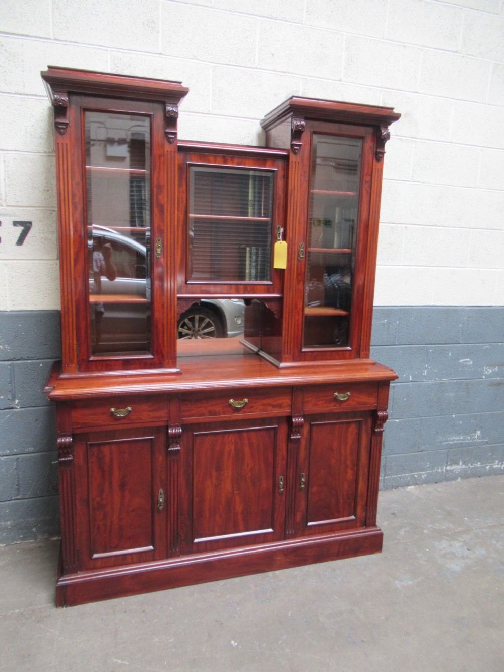 Late Victorian mahogany bookcase featuring glazed upper cabinet sections, carved corbels, fluted pilasters, drawers, and lower panelled doors. View II