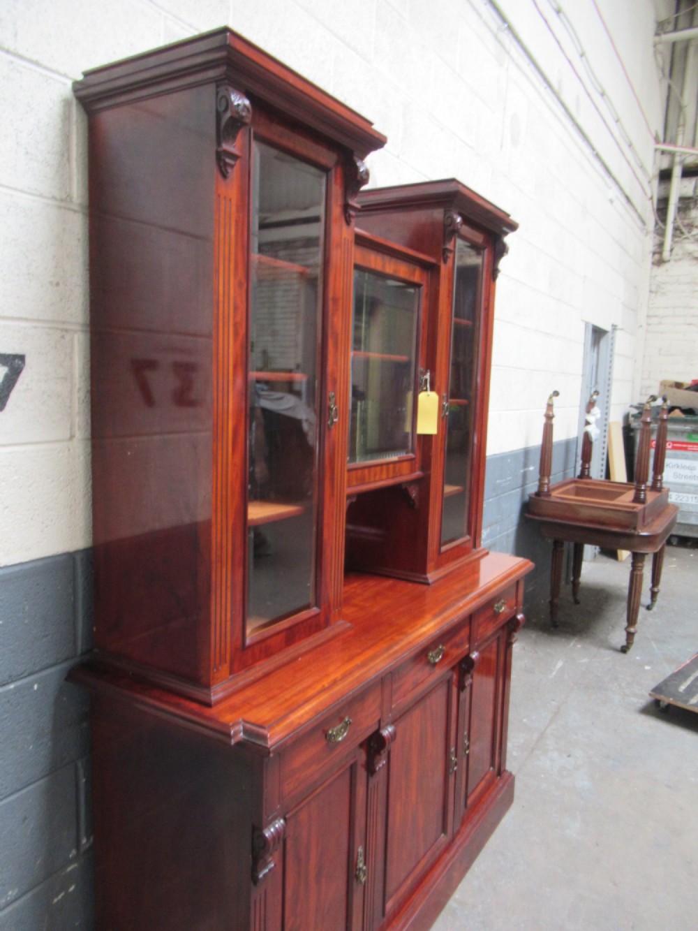 Late Victorian mahogany bookcase featuring glazed upper cabinet sections, carved corbels, fluted pilasters, drawers, and lower panelled doors. View III