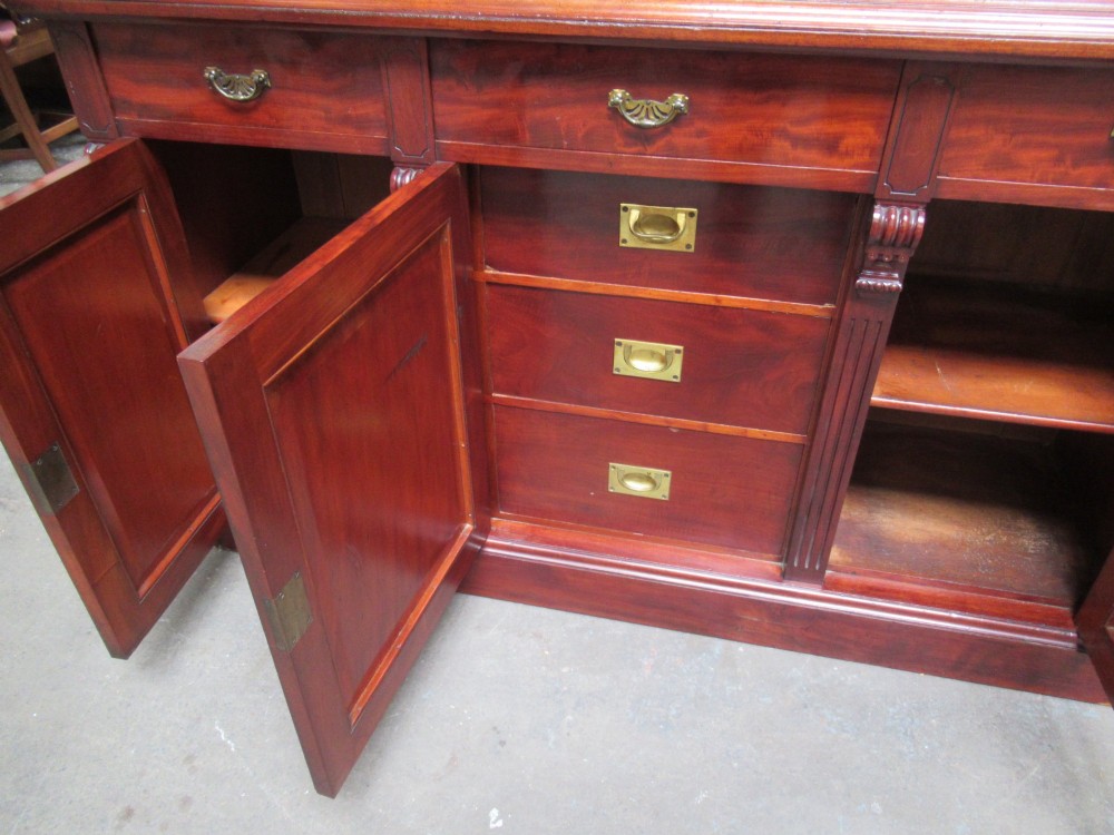 Late Victorian mahogany bookcase featuring glazed upper cabinet sections, carved corbels, fluted pilasters, drawers, and lower panelled doors. View VIII