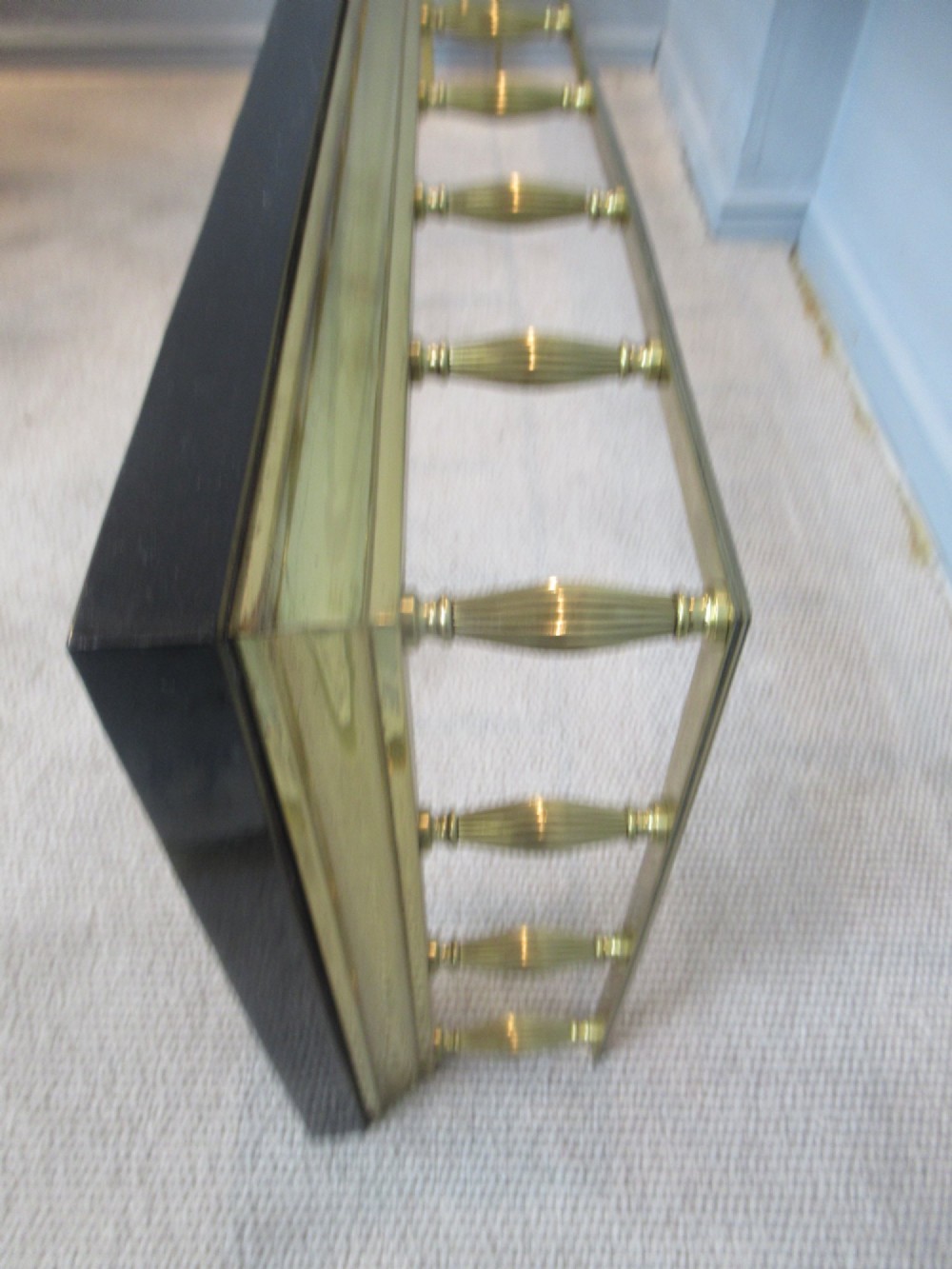 A late Victorian brass and iron fire fender featuring a polished brass top rail with fluted baluster uprights on a heavy black base. View VI