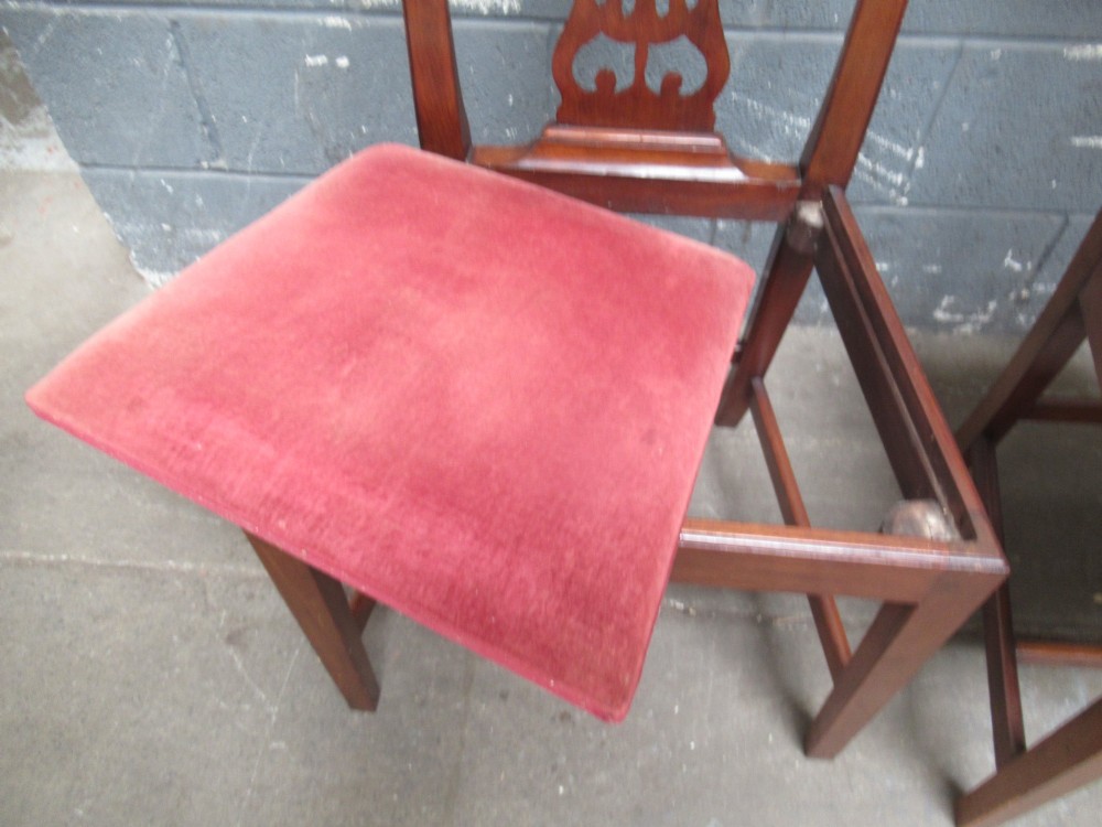 A set of four Edwardian mahogany dining chairs with carved pierced back splats and red velvet upholstered seats. View V