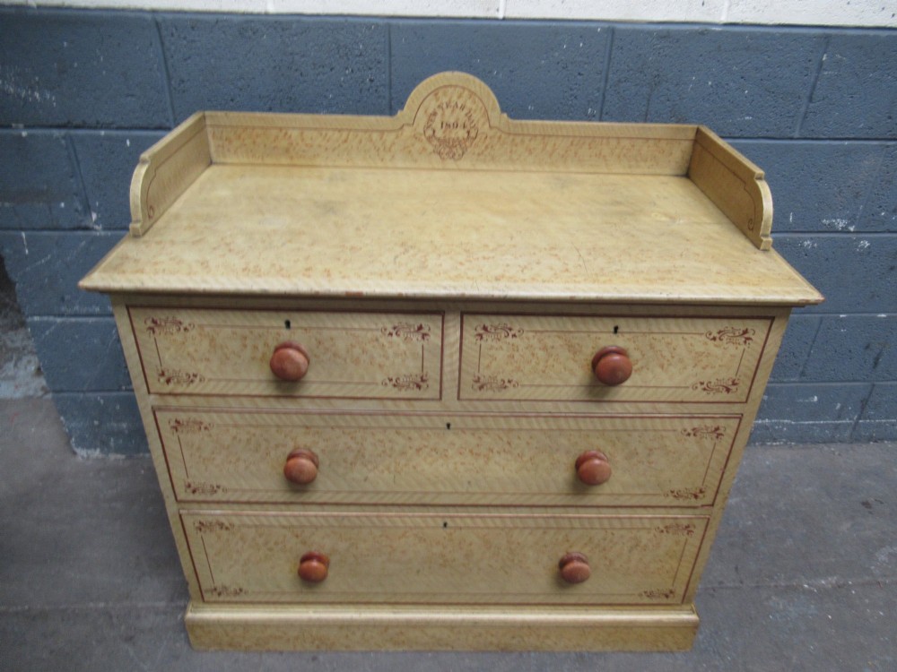 A Victorian painted pine chest of drawers with two short over two long drawers, decorated with scumbled graining, red stencilled borders, turned wooden knobs, and an upstand inscribed New Year Day 1894. View III