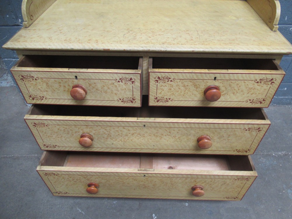 A Victorian painted pine chest of drawers with two short over two long drawers, decorated with scumbled graining, red stencilled borders, turned wooden knobs, and an upstand inscribed New Year Day 1894. View IX