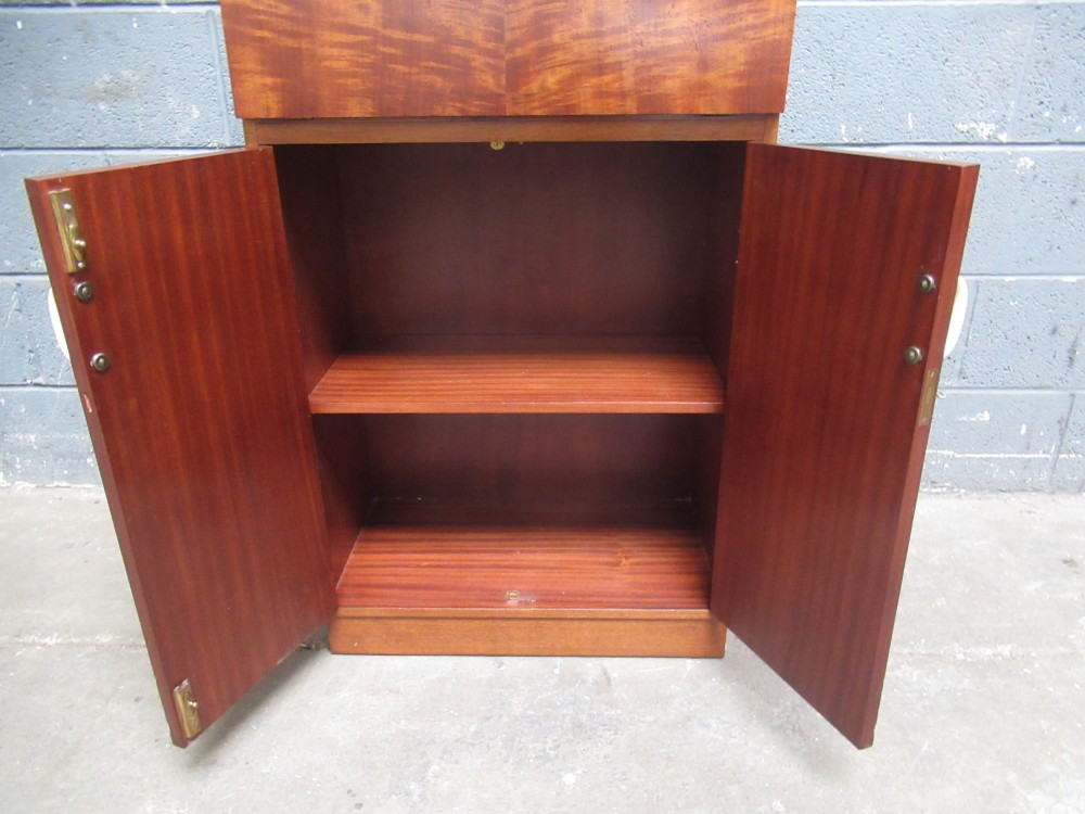 An Art Deco writing bureau in dark brown veneered wood featuring an open fall-front flap that reveals a light-coloured fitted interior with drawers and pigeonholes. View IV