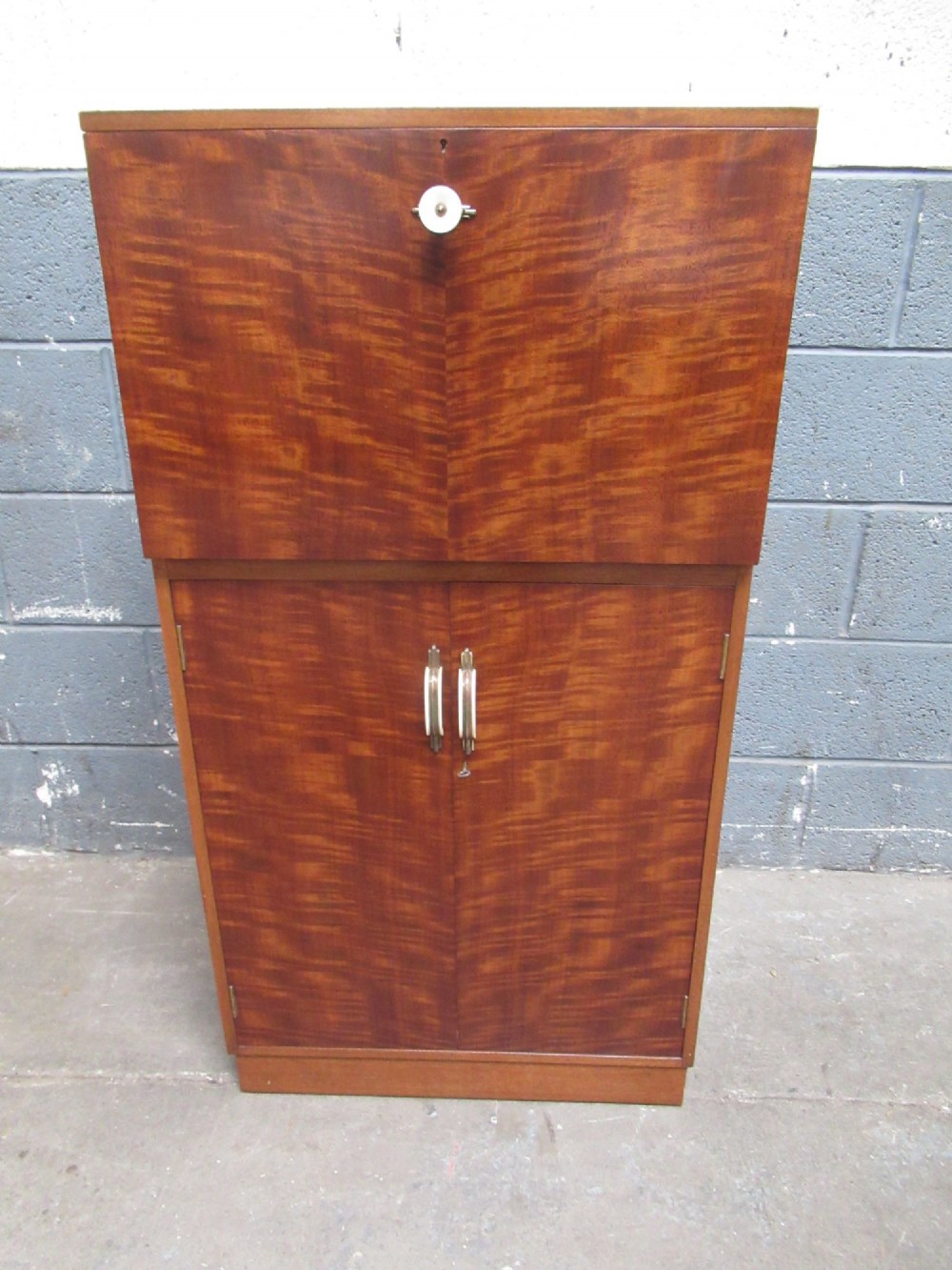 An Art Deco writing bureau in dark brown veneered wood featuring an open fall-front flap that reveals a light-coloured fitted interior with drawers and pigeonholes. View IX