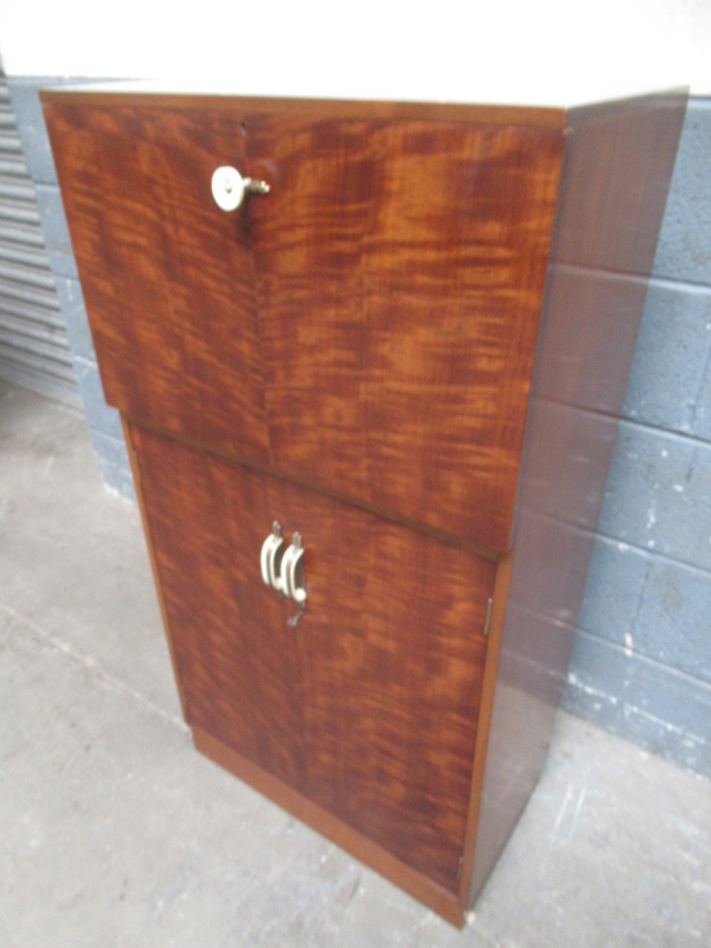 An Art Deco writing bureau in dark brown veneered wood featuring an open fall-front flap that reveals a light-coloured fitted interior with drawers and pigeonholes. View XII