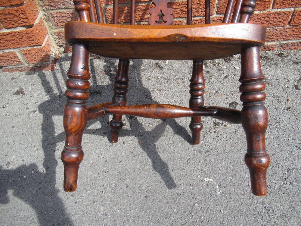 A warm brown wooden childs Windsor armchair with a hoop back, central pierced splat, turned legs, and a solid shaped seat. View VI