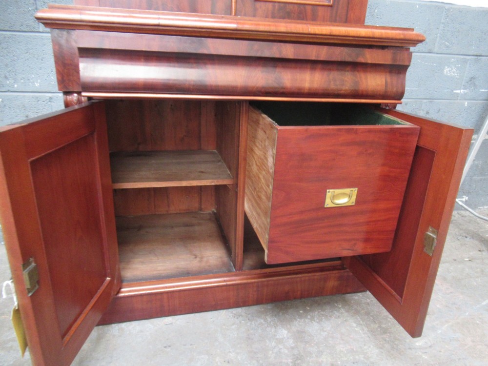 A tall 19th-century Victorian mahogany glazed bookcase featuring a two-door upper section above a lower cupboard base with carved corbels. View VII