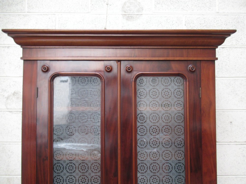 A tall 19th-century Victorian mahogany glazed bookcase featuring a two-door upper section above a lower cupboard base with carved corbels. View XIII