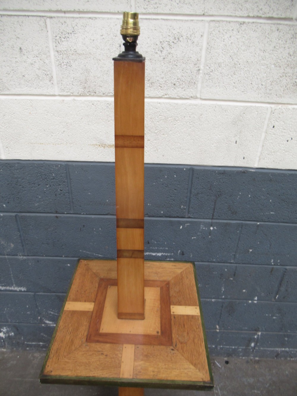 An Art Deco floor lamp crafted from geometric timber marquetry, featuring a central square tray table, a tall square column, and a stepped brass-rimmed base. View VI
