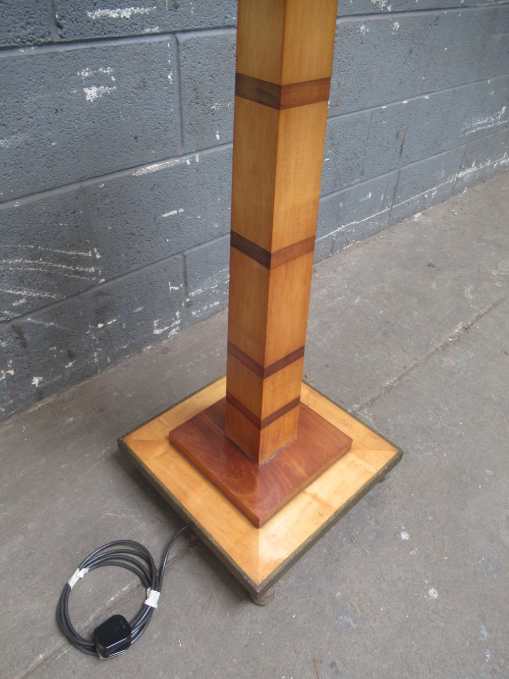 An Art Deco floor lamp crafted from geometric timber marquetry, featuring a central square tray table, a tall square column, and a stepped brass-rimmed base. View VIII