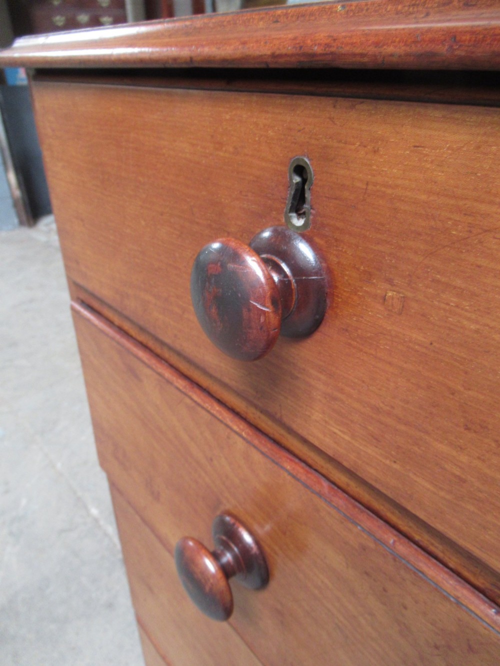 A Victorian mahogany chest of drawers with two short drawers over three long drawers, turned handles, and bracket feet. View VI