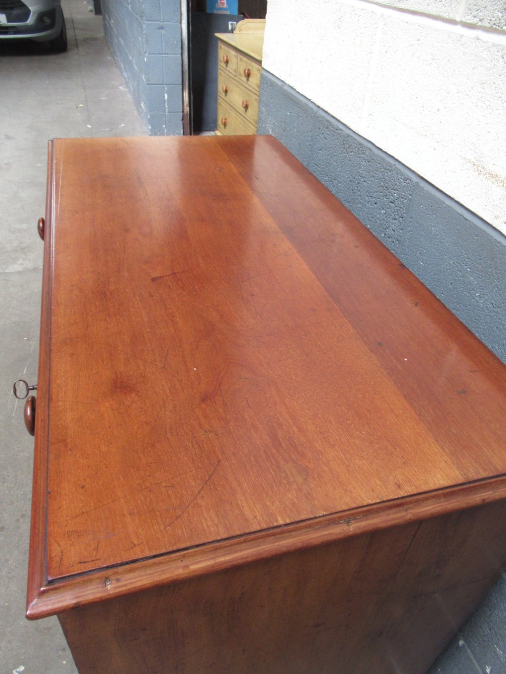 A Victorian mahogany chest of drawers with two short drawers over three long drawers, turned handles, and bracket feet. View VII