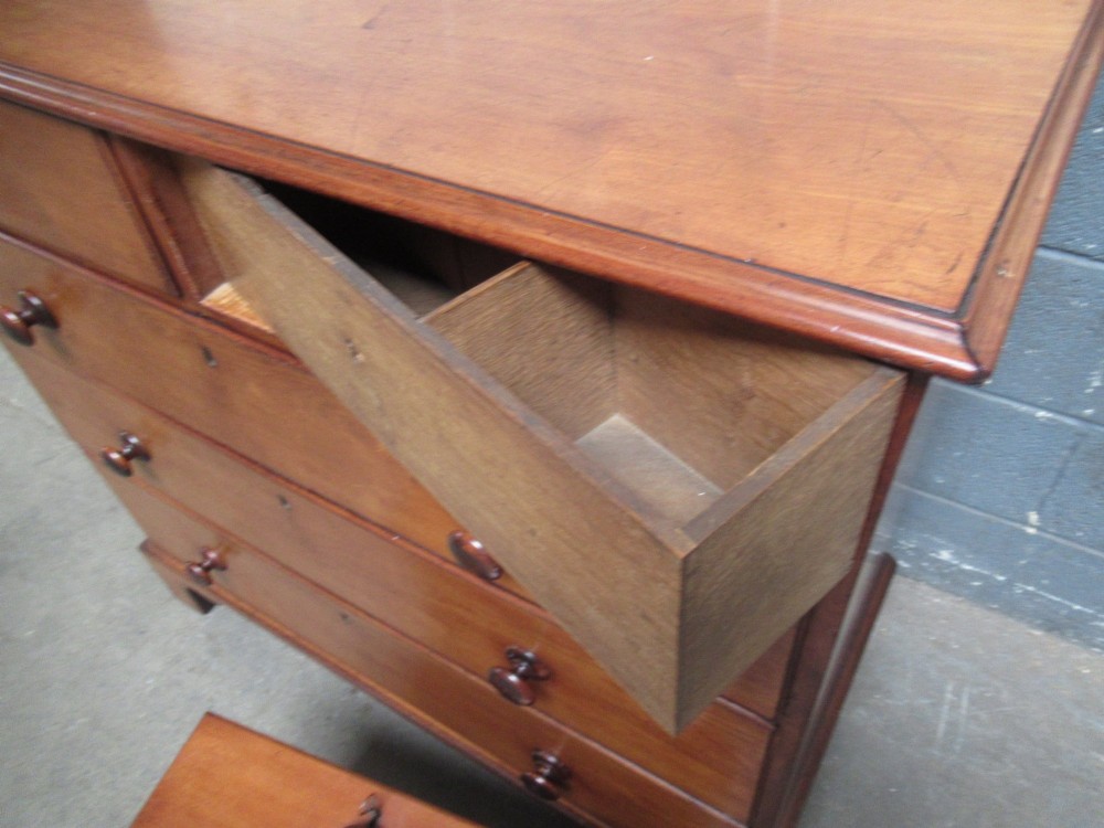 A Victorian mahogany chest of drawers with two short drawers over three long drawers, turned handles, and bracket feet. View IX