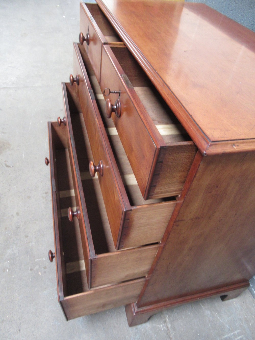 A Victorian mahogany chest of drawers with two short drawers over three long drawers, turned handles, and bracket feet. View XI
