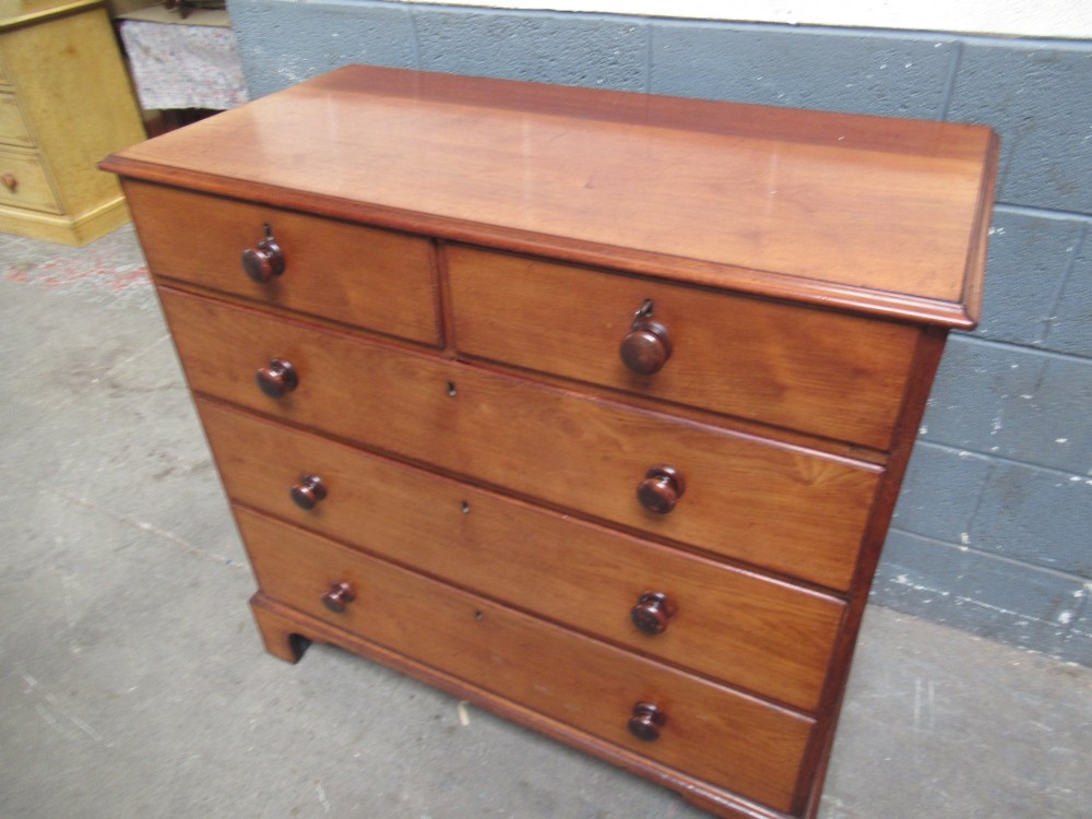 A Victorian mahogany chest of drawers with two short drawers over three long drawers, turned handles, and bracket feet. View XII