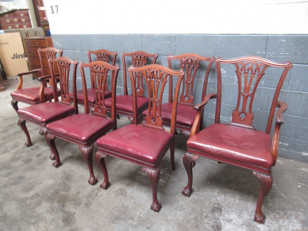 A set of eight mahogany Chippendale style dining chairs featuring carved pierced splats, red leather seats with brass studding, and cabriole legs with ball and claw feet. View II