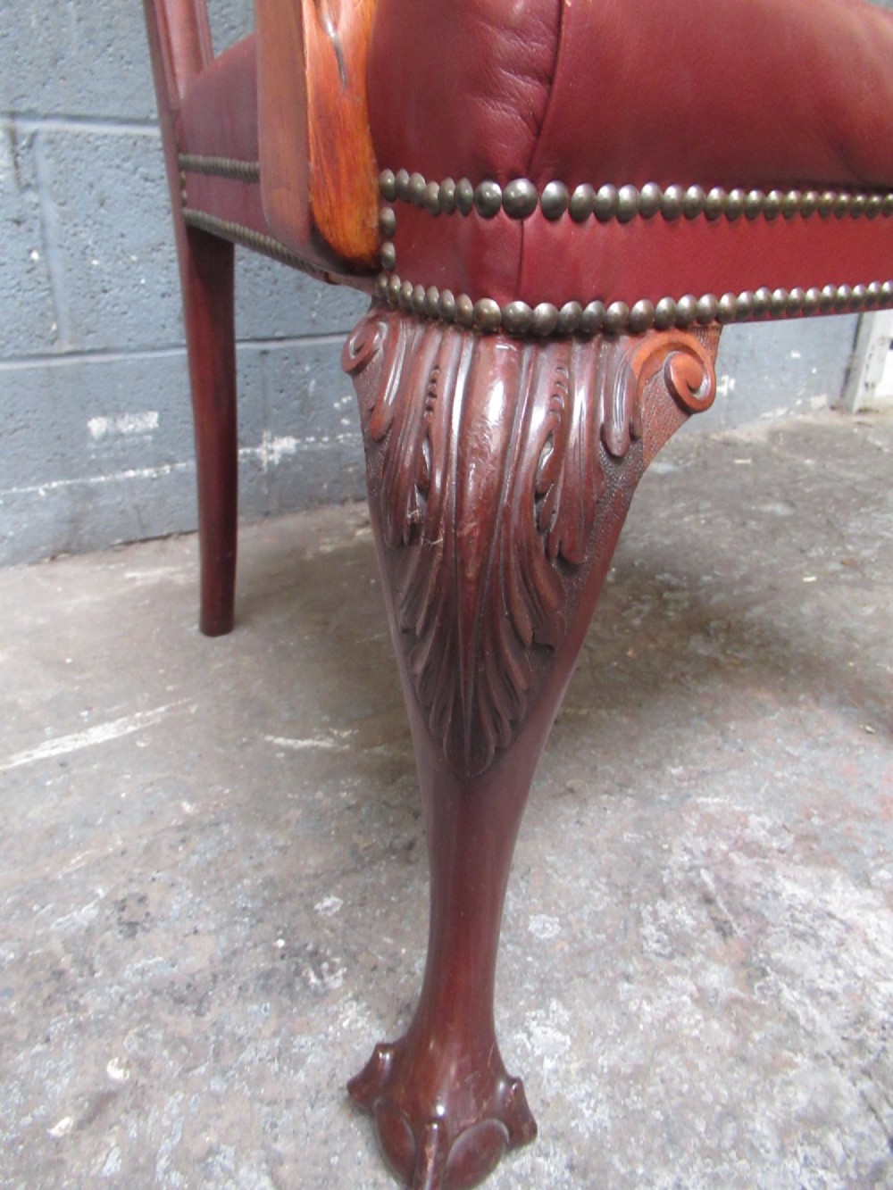 A set of eight mahogany Chippendale style dining chairs featuring carved pierced splats, red leather seats with brass studding, and cabriole legs with ball and claw feet. View V